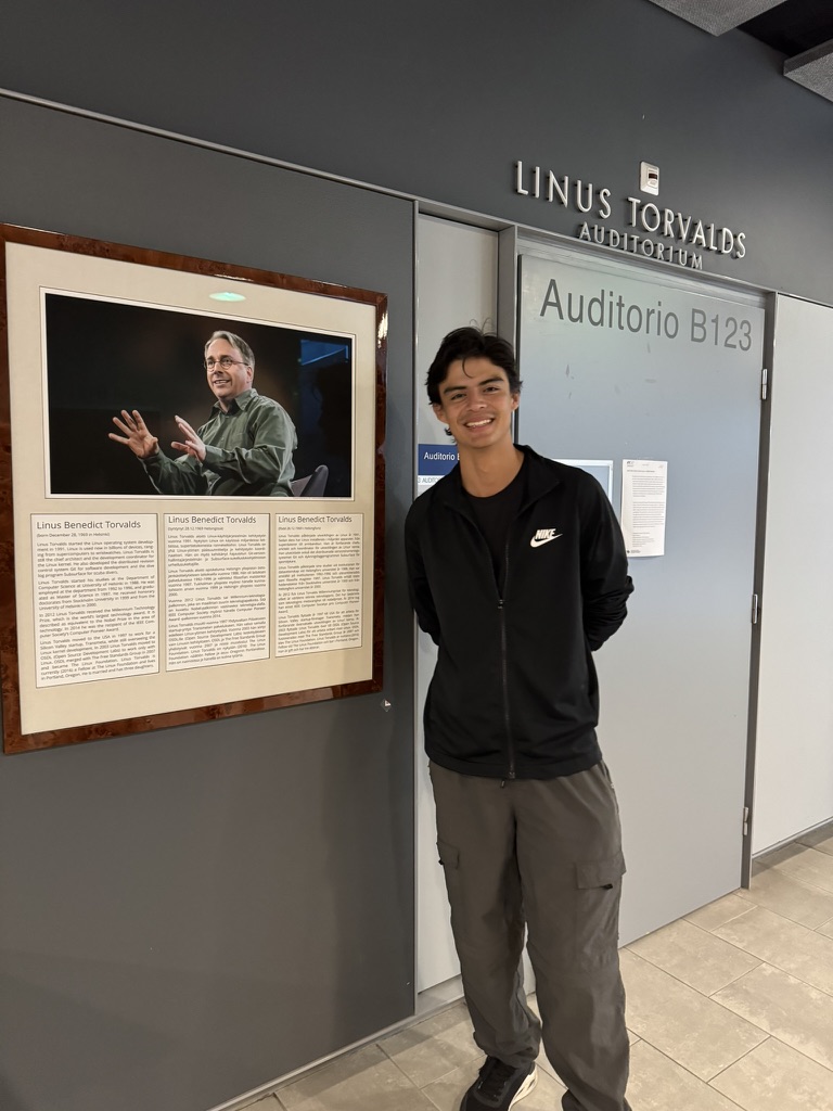 Roberto Villafuerte junto a un retrato de Linus Torvalds en la Universidad de Helsinki
